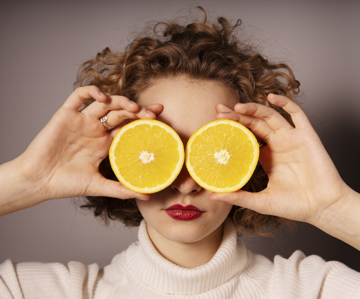 Femme énergique tenant une orange — vitalité et énergie naturelle