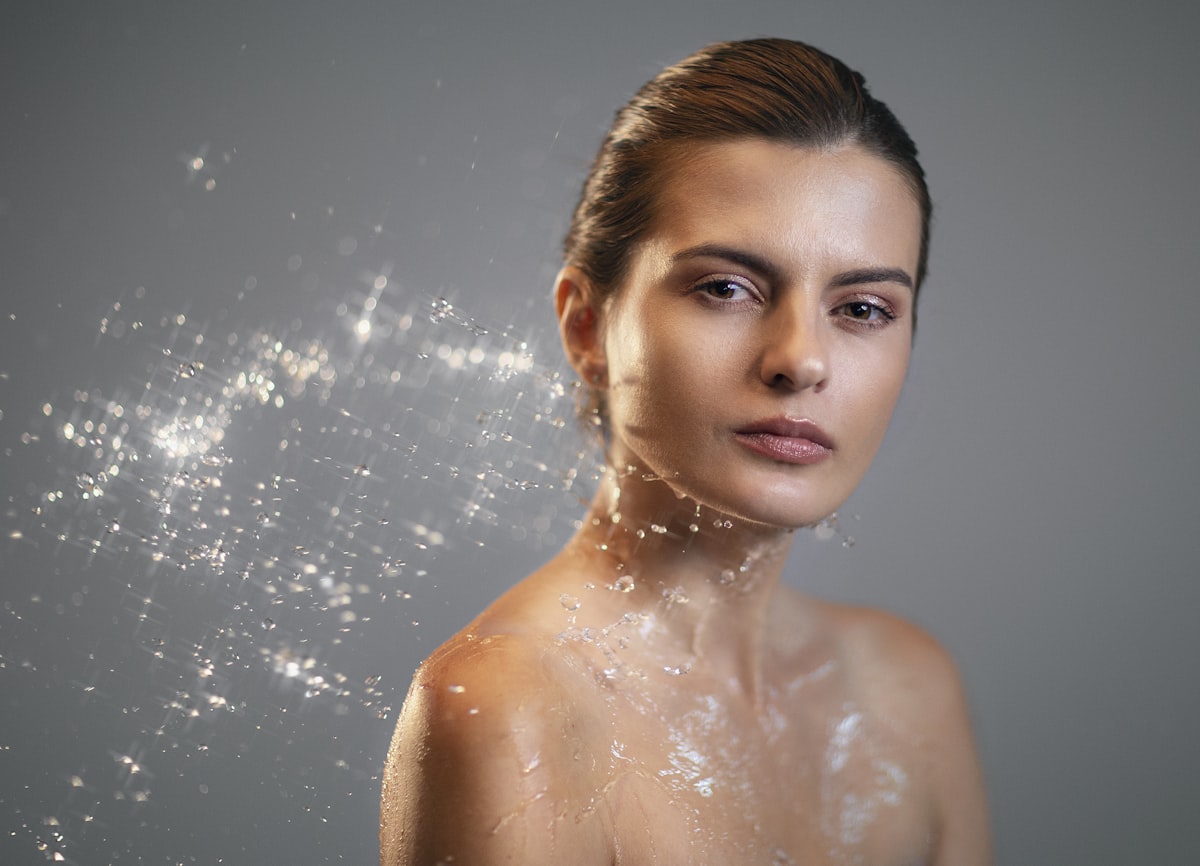 Femme qui se nettoie le visage, soin peau hydratation naturelle