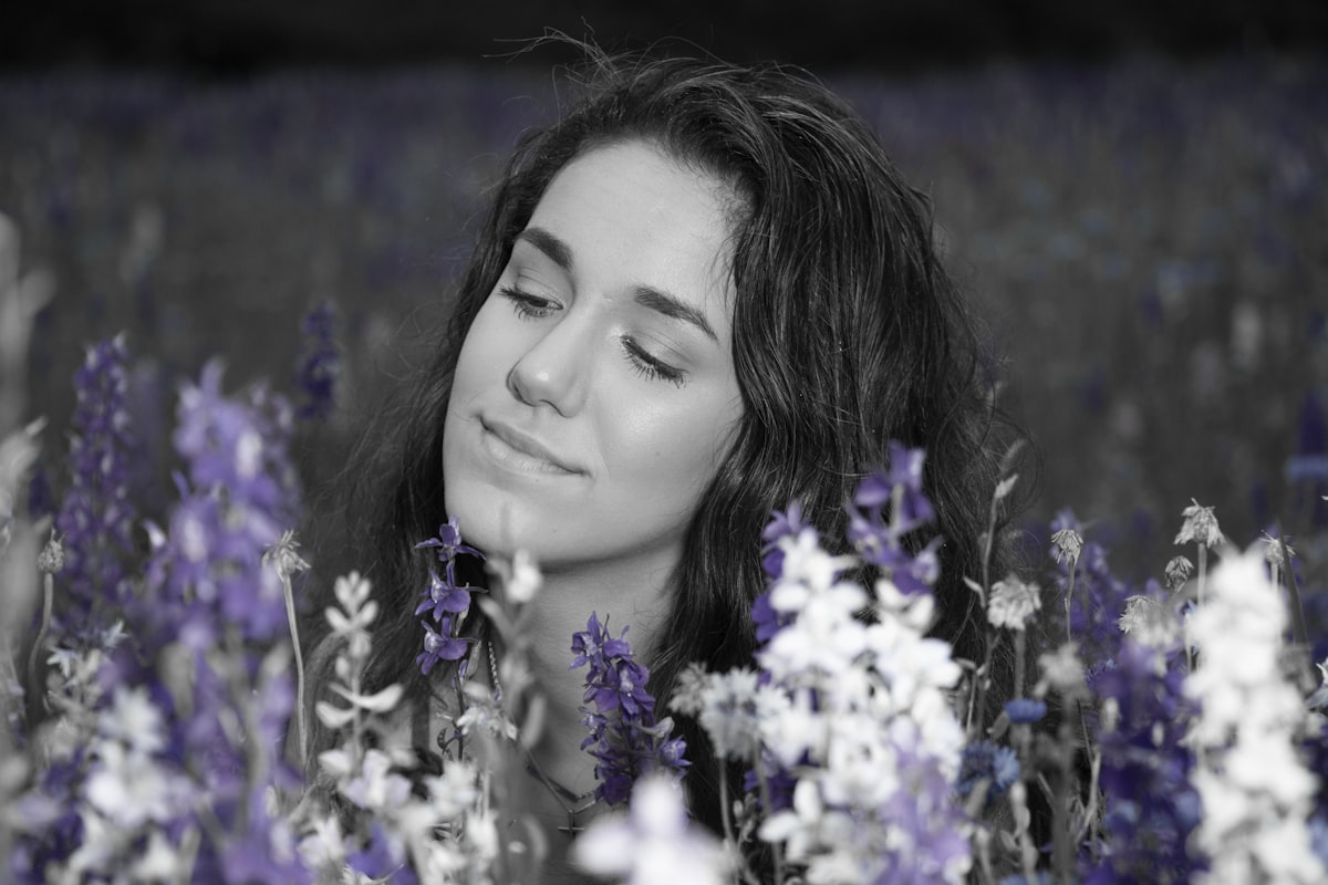 Femme sereine les yeux fermés entourée de fleurs — sommeil réparateur naturel